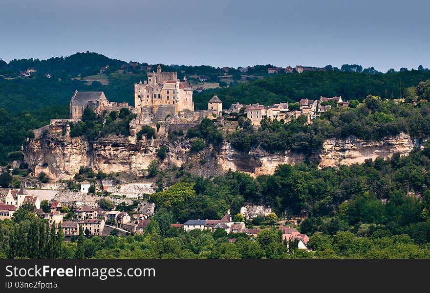 View over the valley to a French hillside town with Chateau