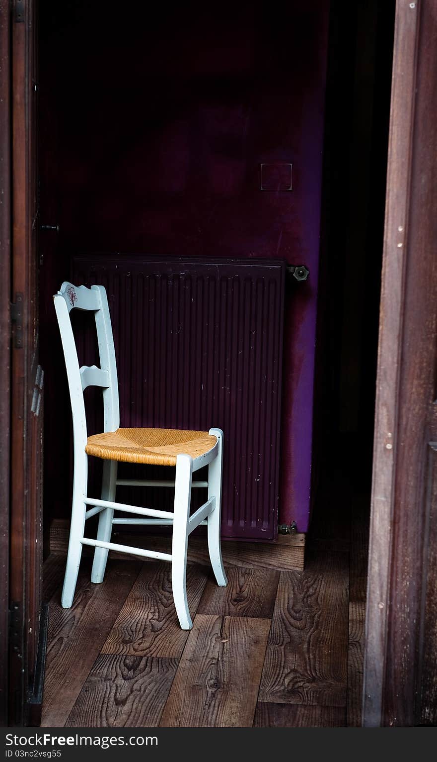 Single white chair in a doorway with purple background