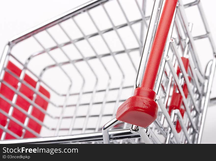 Empty shopping cart with the red handle on a white background.