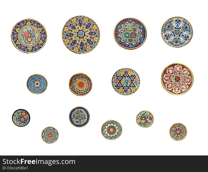 14 painted round wall-plates diferent sizes against a white background