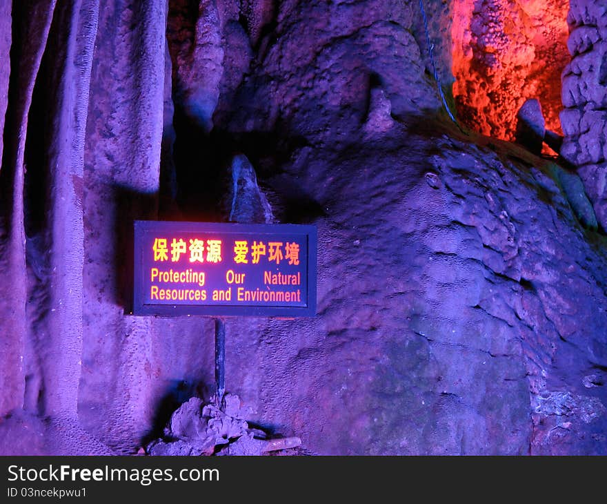 Stalactite with a sign board saying protect the environment, in the cave Yinziyan, Yangshuo, Guilin, China