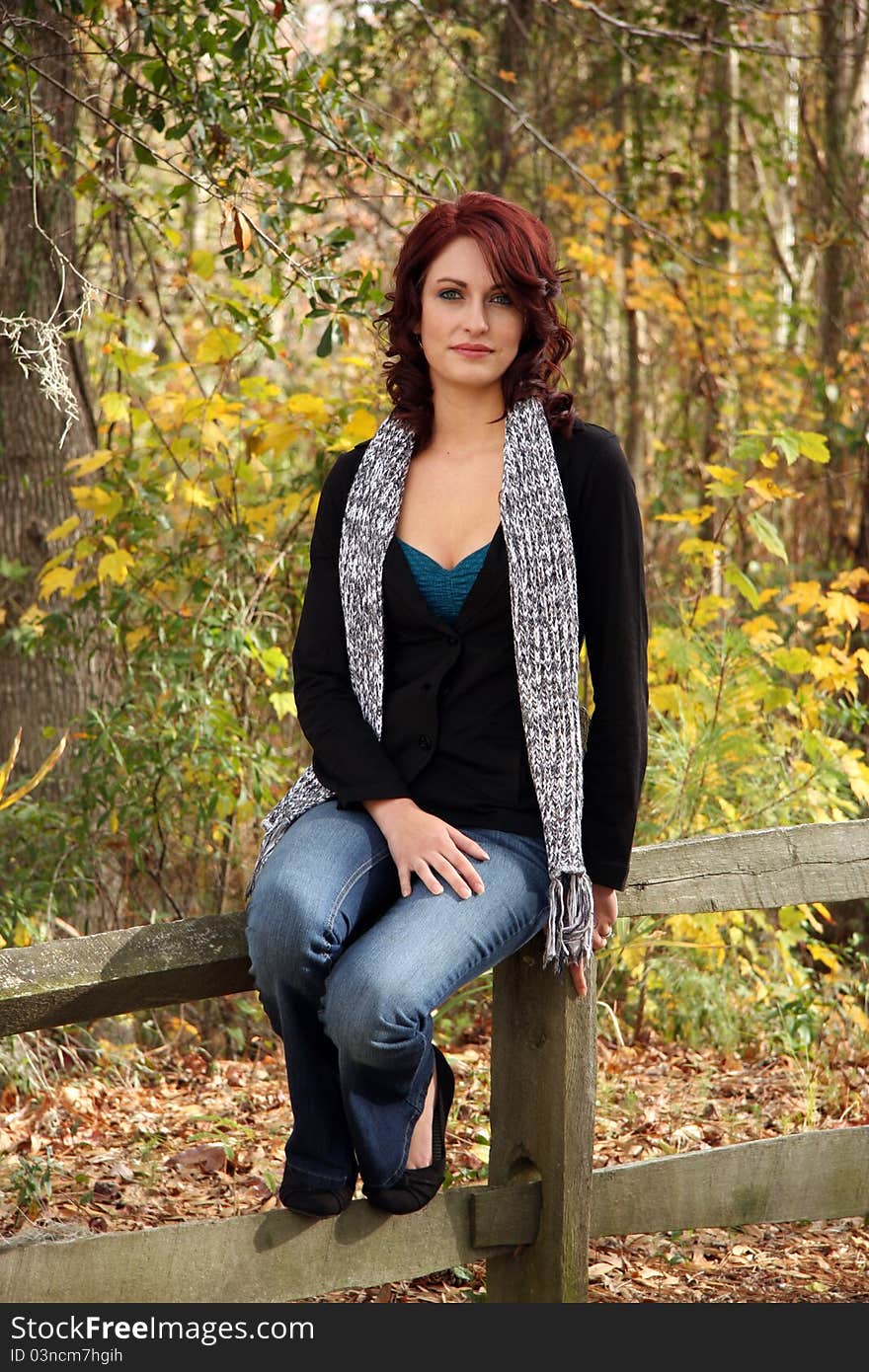 A Young Caucasian woman poses for portrait in an Autumn Setting. A Young Caucasian woman poses for portrait in an Autumn Setting.