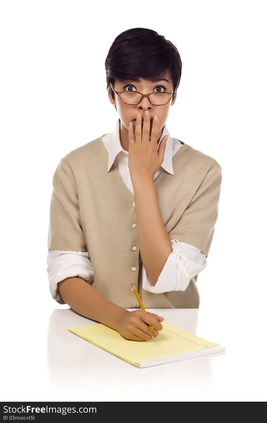 Shocked Mixed Race Young Adult Female Student at Table with Pad of Paper and Pencil Isolated on a White Background.