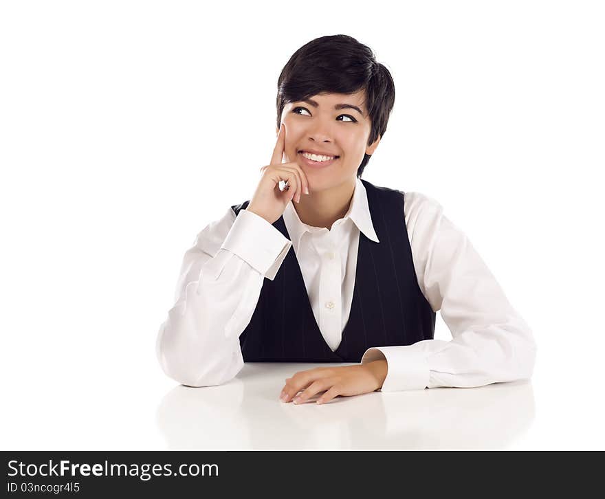 Attractive Smiling Mixed Race Young Adult Female At White Table Looking Up and Away on a White Background. Attractive Smiling Mixed Race Young Adult Female At White Table Looking Up and Away on a White Background.