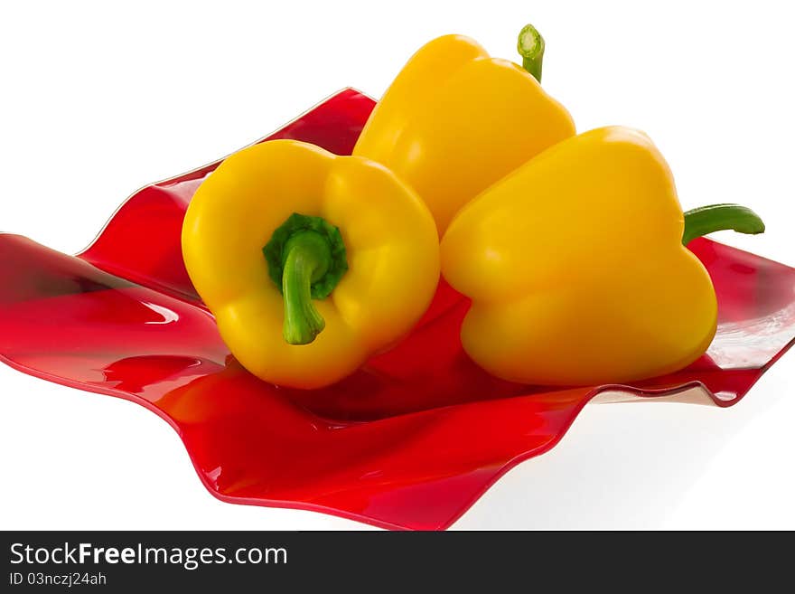 Yellow bell pepper on a red plate.