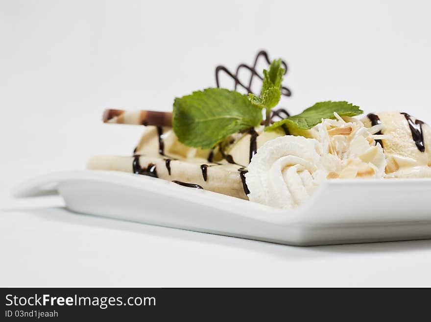 Cold and fresh ice cream dessert with lot of chocolate, and vanilla ice,on a white blow before a white background. Cold and fresh ice cream dessert with lot of chocolate, and vanilla ice,on a white blow before a white background