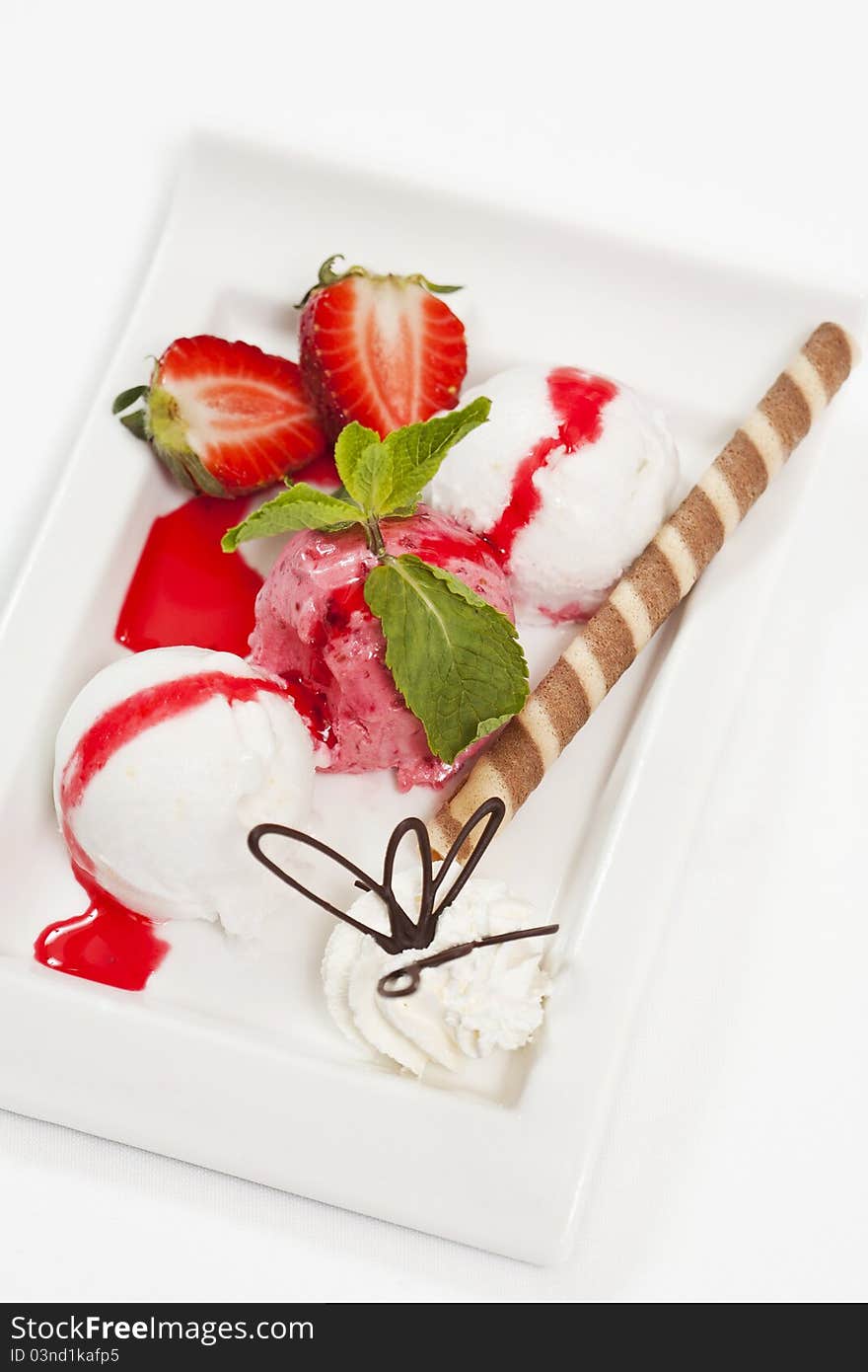 Fresh fruits dessert with ice cream, strawberry, and mint, strawbery sause on the top, and with lemon and strawbery ice. Fresh fruits dessert with ice cream, strawberry, and mint, strawbery sause on the top, and with lemon and strawbery ice