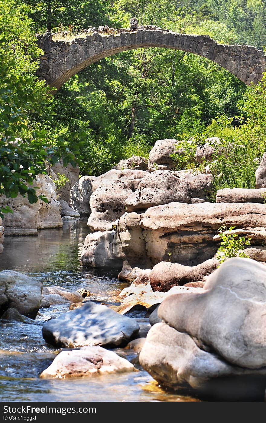 An ancient stone bridge crossing a river. An ancient stone bridge crossing a river