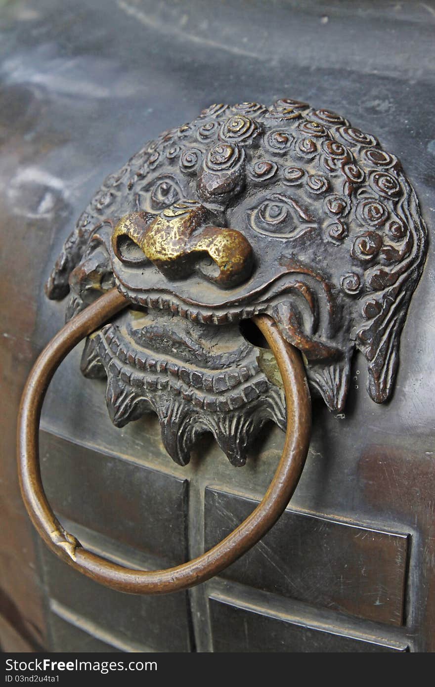 Lion head on a chinese copper censer surface. Lion head on a chinese copper censer surface