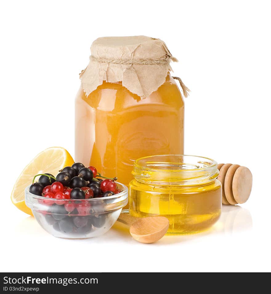 Glass jar full of honey, lemon and berry isolated on white background