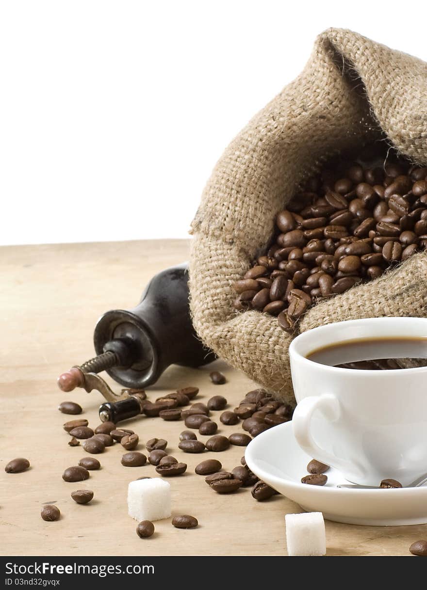 Cup of coffee and grinder with roasted beans isolated on white background