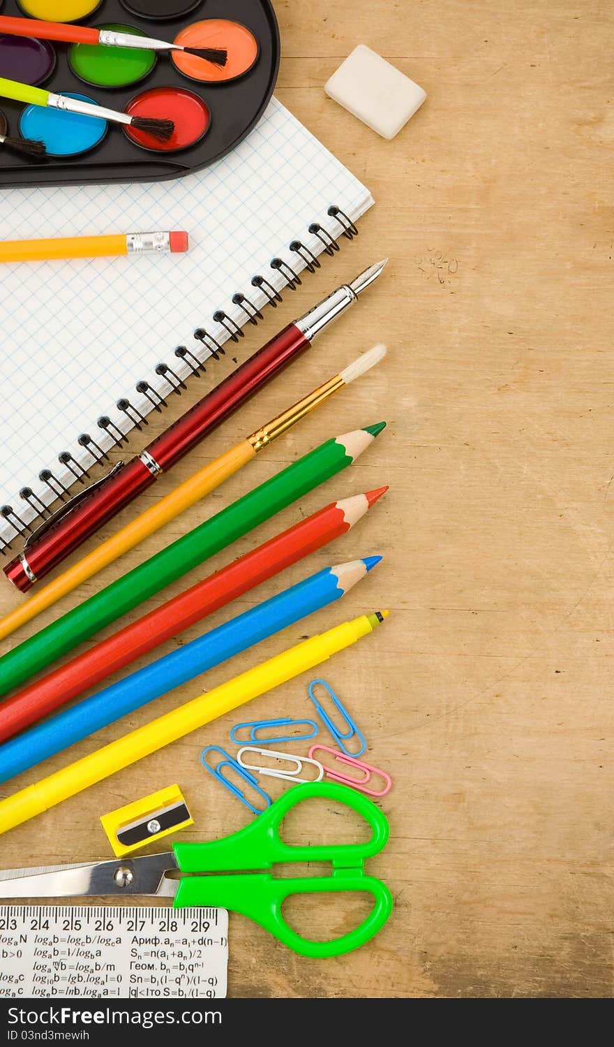 School accessories and checked notebook on wooden table