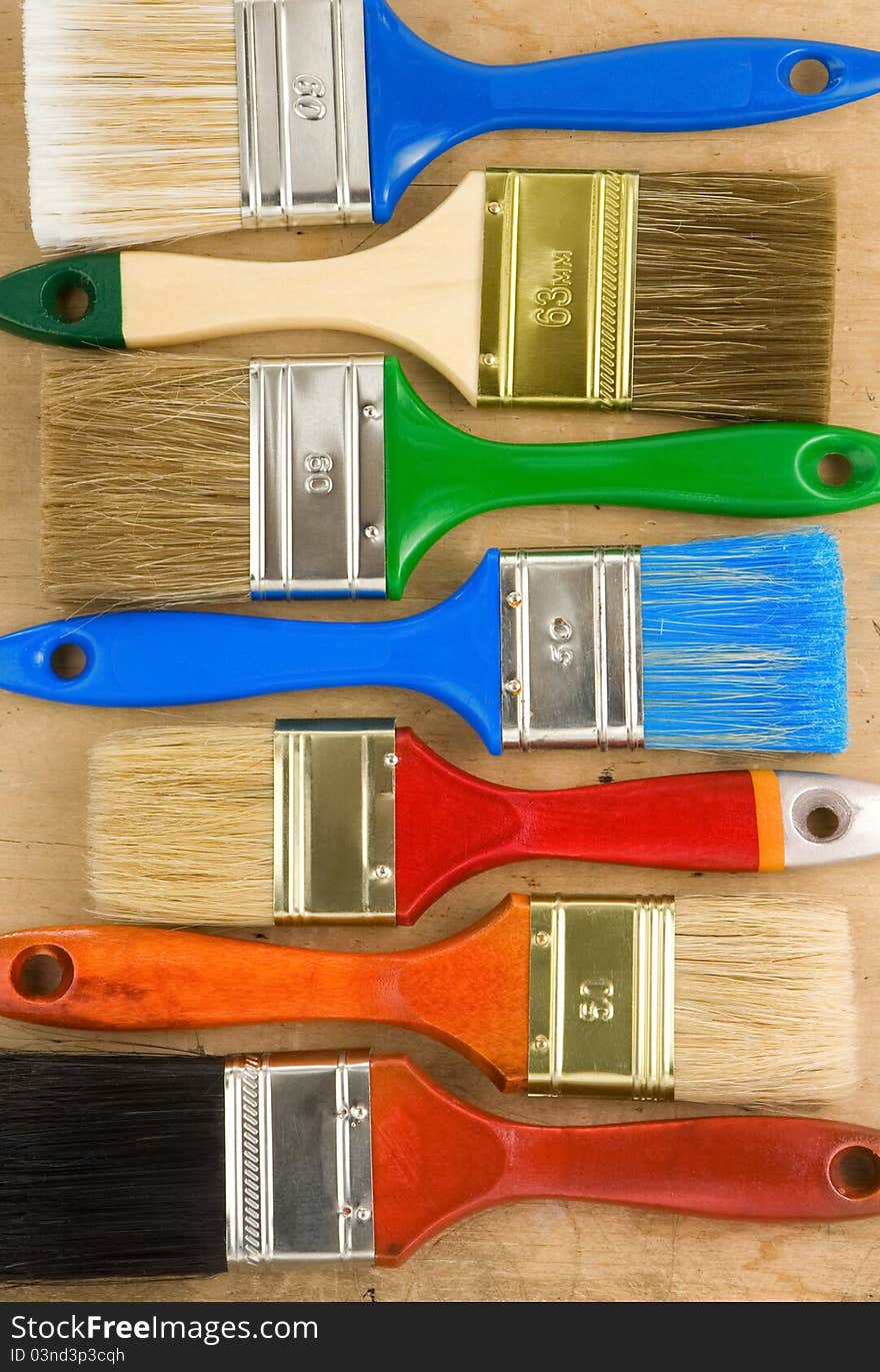 Colorful paintbrush on wooden background