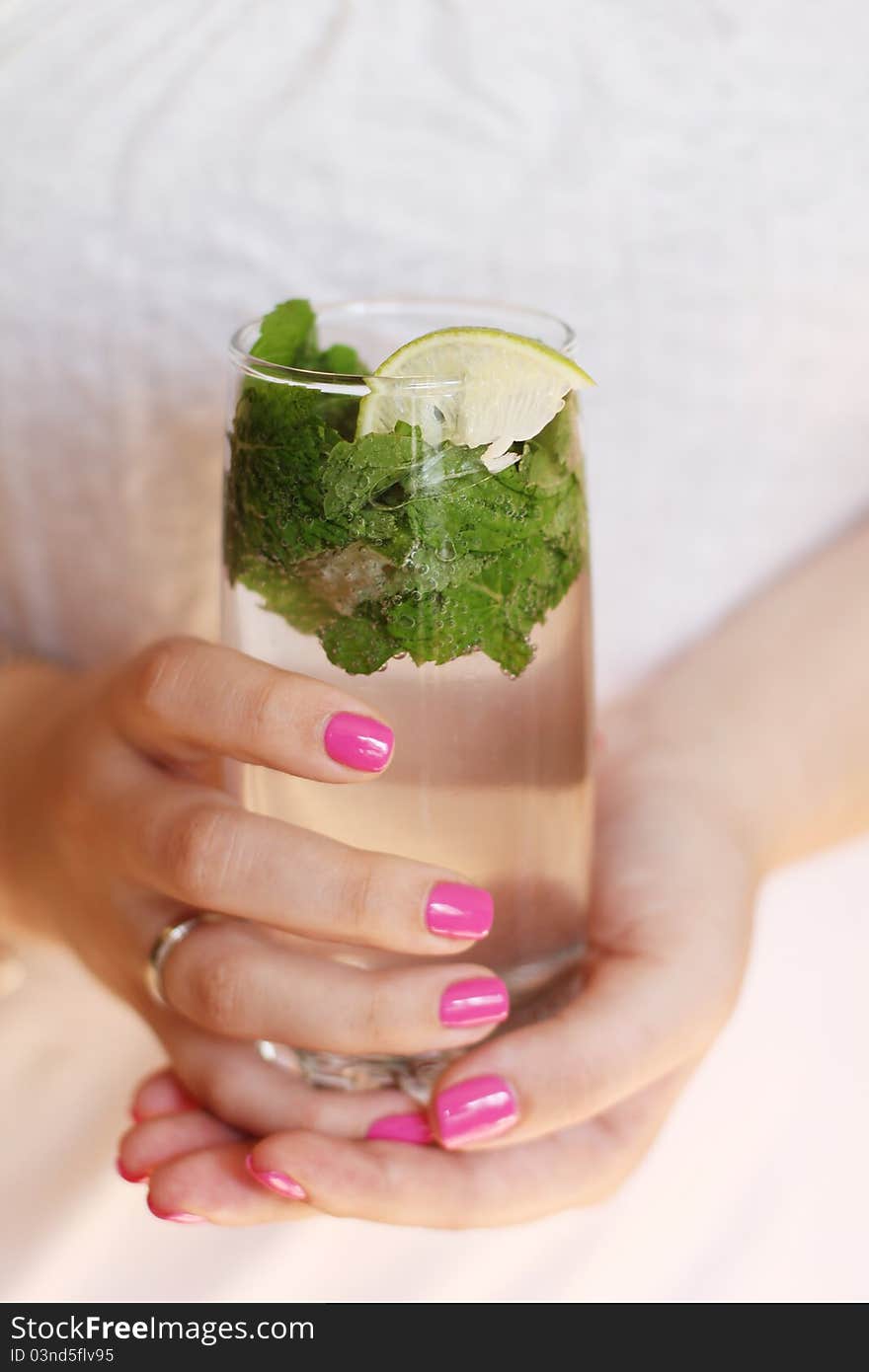 Mojito with lime and mint in the hands