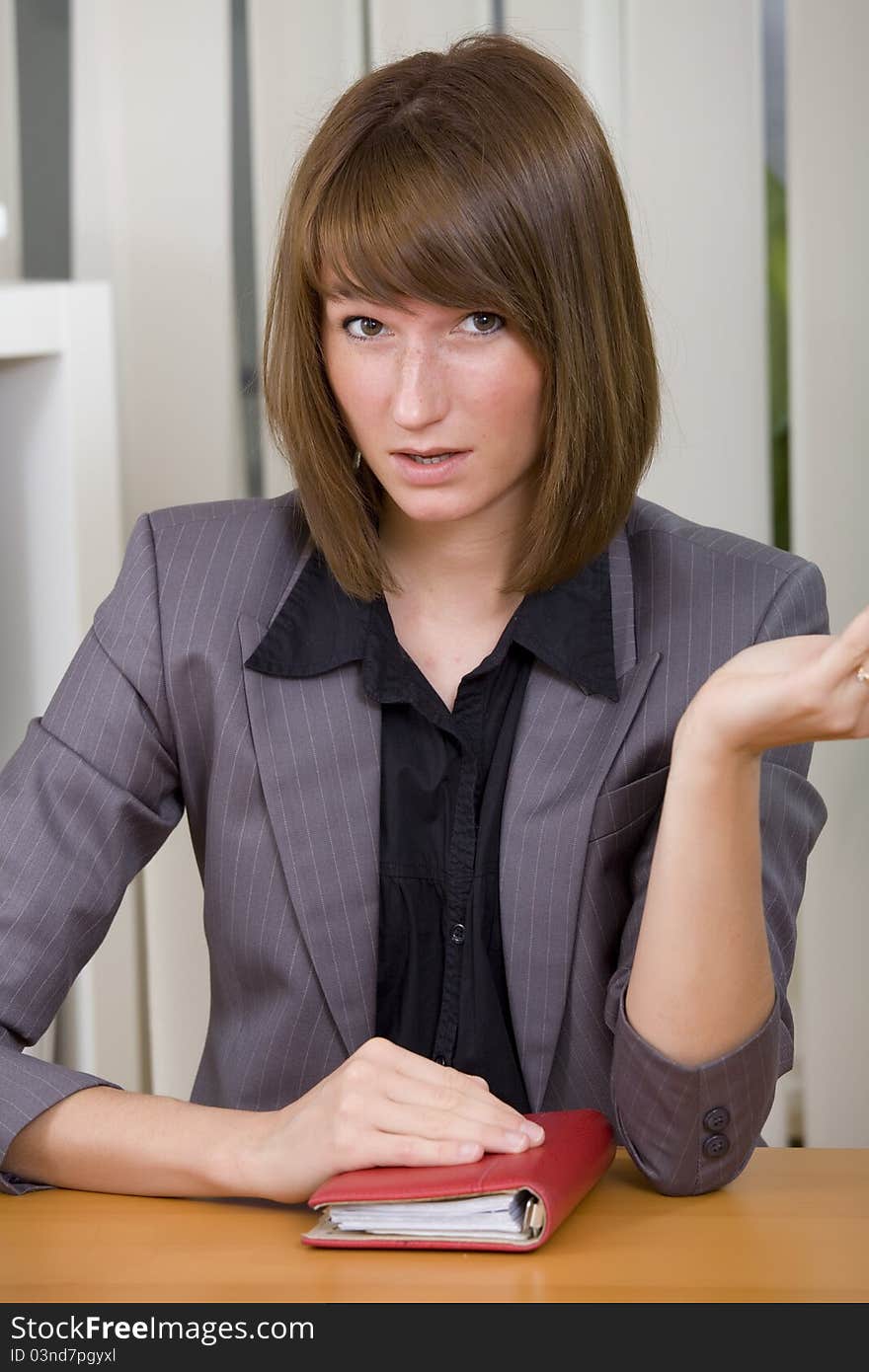 Young businesswoman or secretary with diary in stress by office work. Young businesswoman or secretary with diary in stress by office work