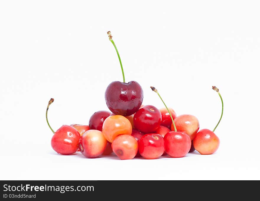 Pile of yellow and red cherries on white background