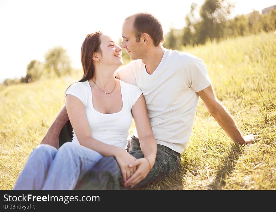 Happy young couple spending time outdoor on a summer day at sunset