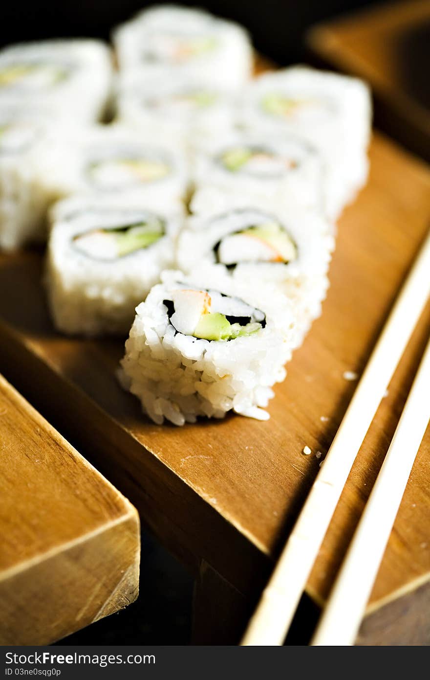 Sashimi made with salmon, rice, wassabi paste, cucumbers and algaes. Elegantly presented on a wooden platou with asian sticks for service. Sashimi made with salmon, rice, wassabi paste, cucumbers and algaes. Elegantly presented on a wooden platou with asian sticks for service.