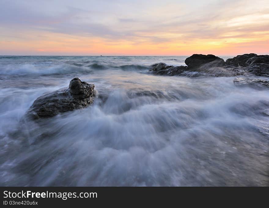 Sunrise over sea with rock coast