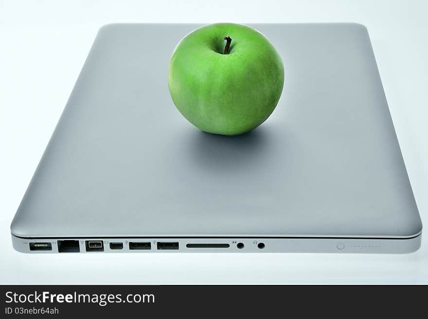 Laptop with green apple on the cover. Laptop with green apple on the cover.