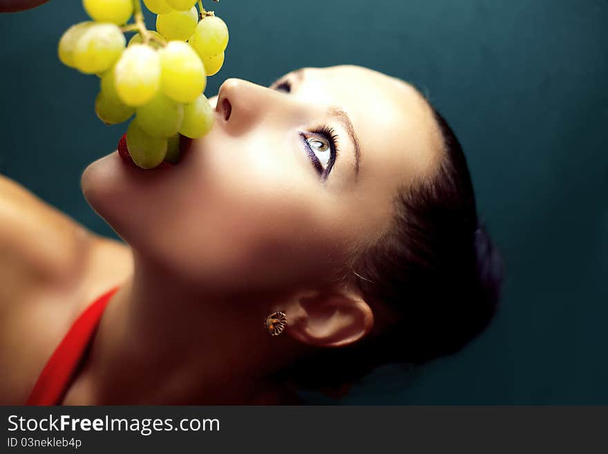 Young woman eating grapes.