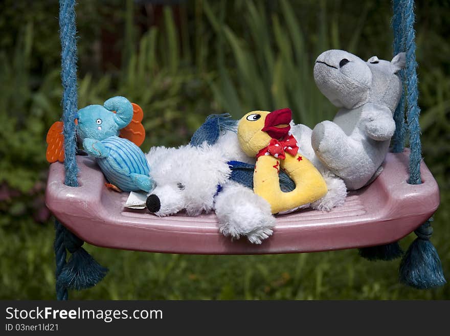 Photo of some stuffed animals on a rocker. Photo of some stuffed animals on a rocker