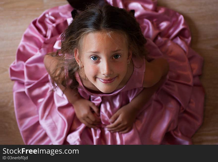 Smiling cute little girl in a pink dress festive