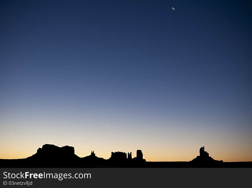 This is a picture of monument valley taken from a distance. The silhouette of the Sentinel Mesa, East Mitten, West Mitten, Merrick Butte and Elephant Butte can be seen. This is a picture of monument valley taken from a distance. The silhouette of the Sentinel Mesa, East Mitten, West Mitten, Merrick Butte and Elephant Butte can be seen.