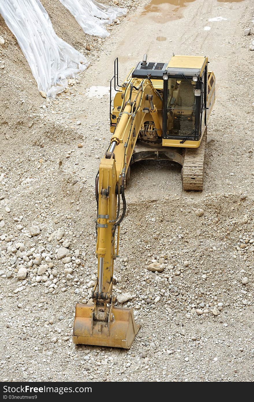 Yellow digger in the yard with shovel gravel and caterpillar. Yellow digger in the yard with shovel gravel and caterpillar