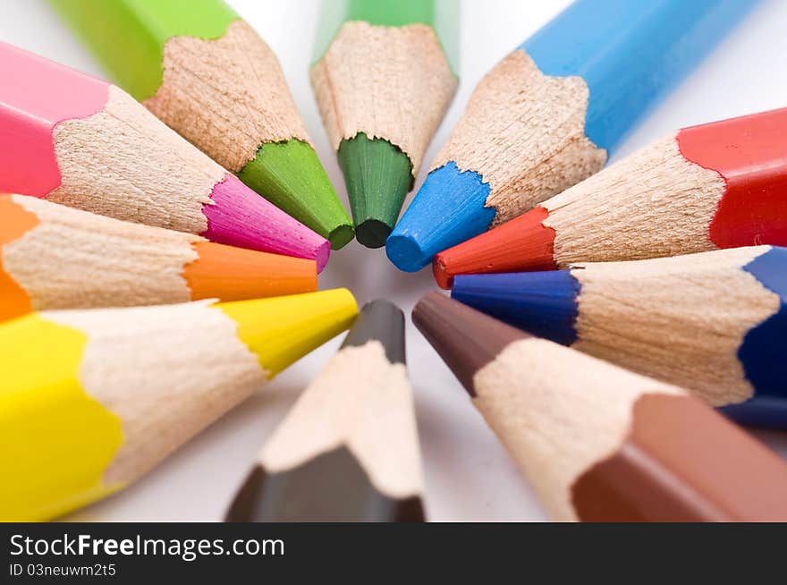 Color pencils in arrange in color wheel colors on white background