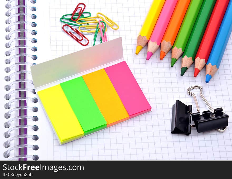 Colorful pencils and note papers on white