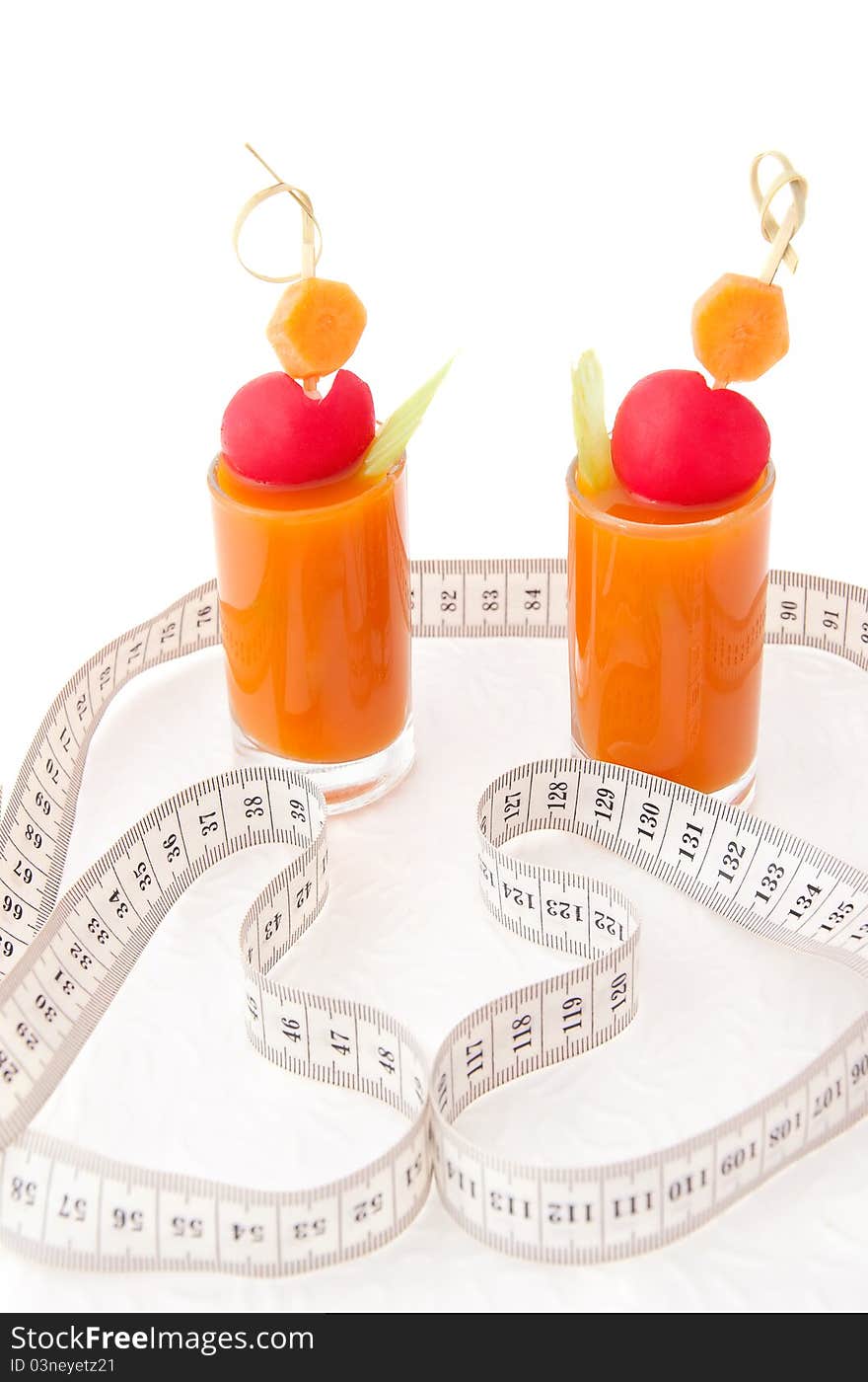 Vegetable juice in two short glasses with tape measure on white background, concept of healthy food. Vegetable juice in two short glasses with tape measure on white background, concept of healthy food