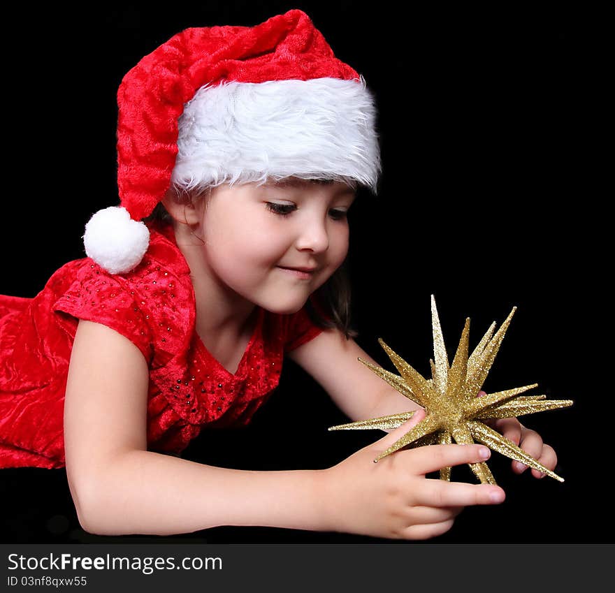 Girl in Christmas outfit playing with golden star