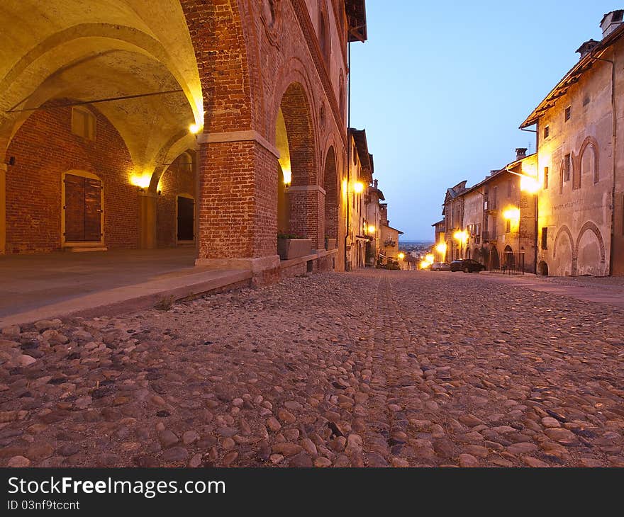 Night view of a typical street of the old town of Saluzzo