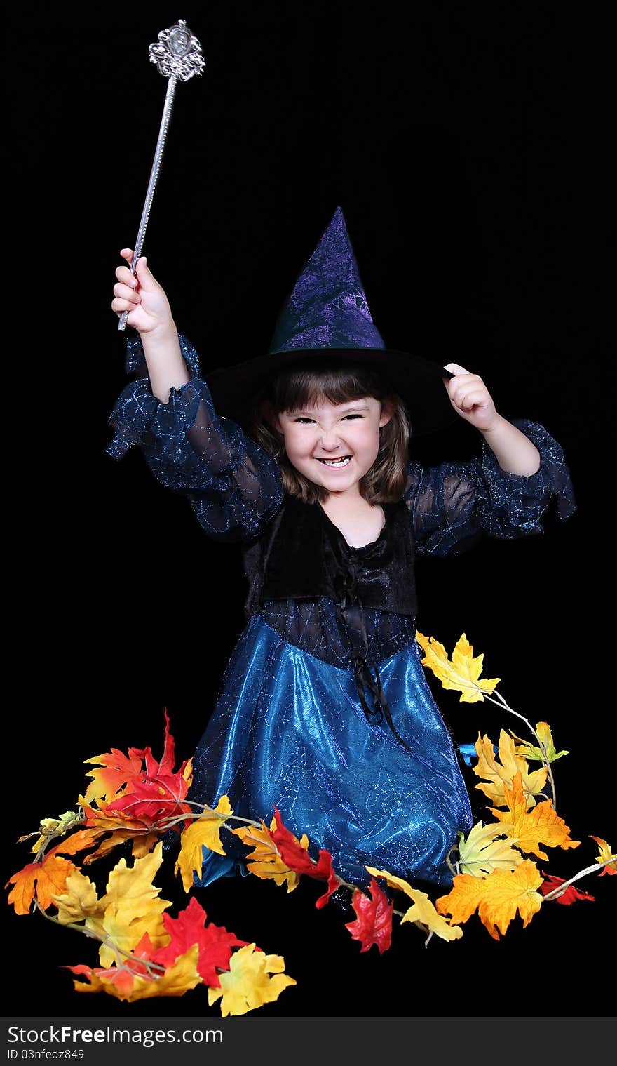 Fun little witch making a scary face surrounded by golden fall leaves. isolated. Fun little witch making a scary face surrounded by golden fall leaves. isolated