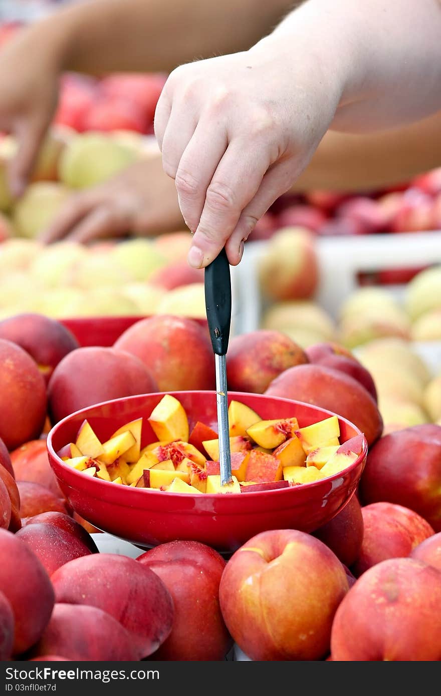 Hand reaching for a piece of nectarine. Hand reaching for a piece of nectarine.