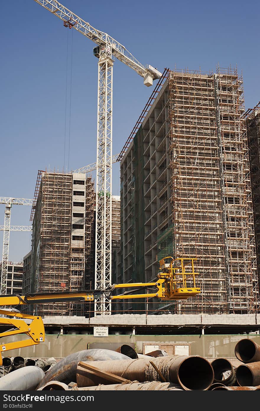 Building Construction in the Middle East with a Massive Tower Crane dwarfing everything. Building Construction in the Middle East with a Massive Tower Crane dwarfing everything