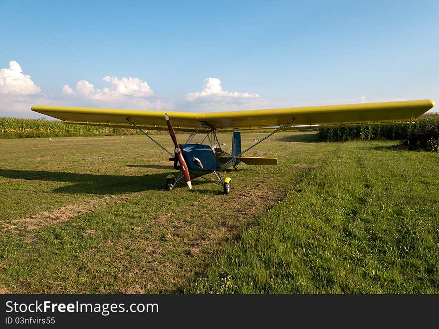 Small microlight aircarft parked in an airfield. Amateur built from plans 2-stroke engine, type Bagalini Colombo. Small microlight aircarft parked in an airfield. Amateur built from plans 2-stroke engine, type Bagalini Colombo