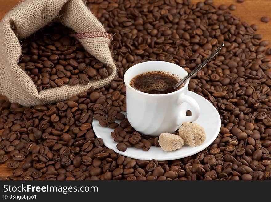 Coffee cup with burlap sack of roasted beans