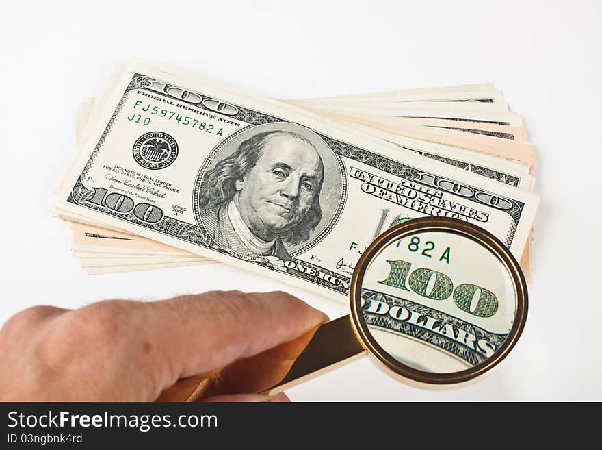 Magnifying a hundred dollar bill with golden color loupe