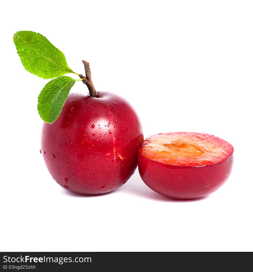 Fresh plum and a half with leafs isolated on white background