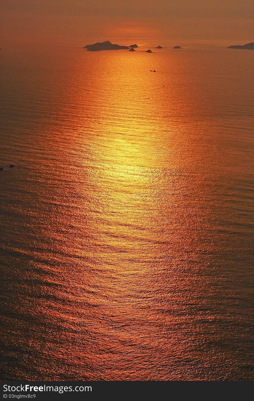 The sun is going down and the golden glow makes the sea in a golden color. The sun is going down and the golden glow makes the sea in a golden color.