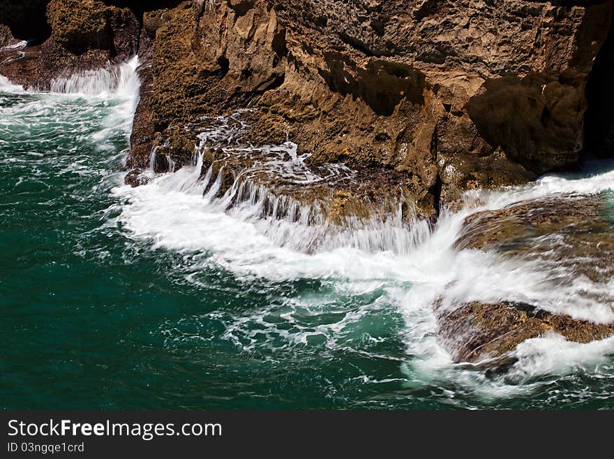 Intense ocean waves in chasm Boca do inferno located in the seaside cliffs close to the Portuguese city of Cascais. Tourists come here to see the waves crash into the rock. Intense ocean waves in chasm Boca do inferno located in the seaside cliffs close to the Portuguese city of Cascais. Tourists come here to see the waves crash into the rock.