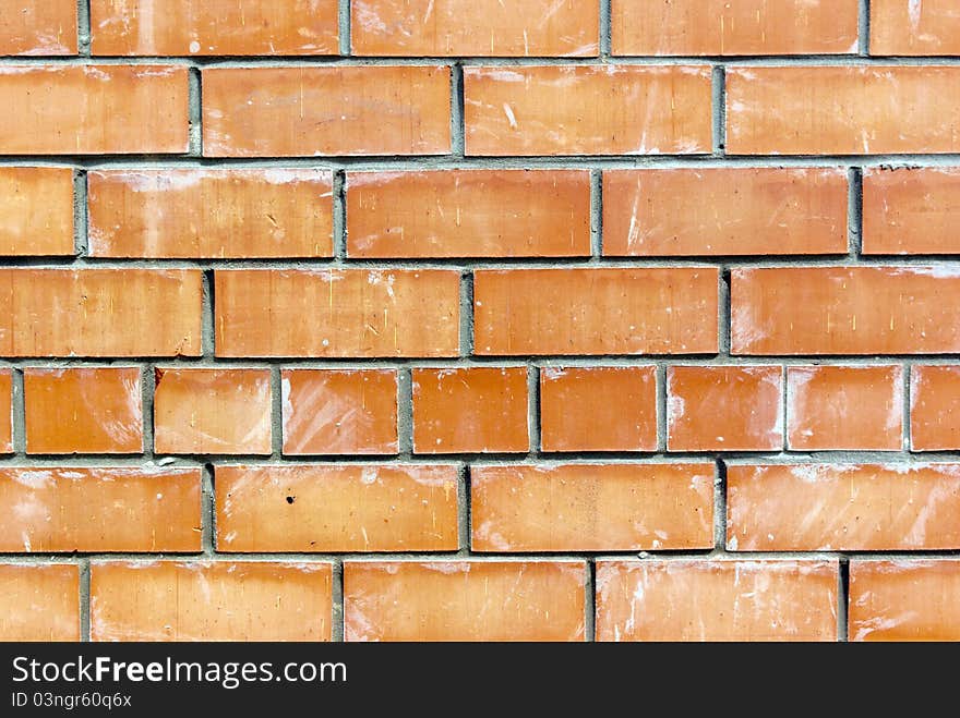 The old weathered stained red brick wall background