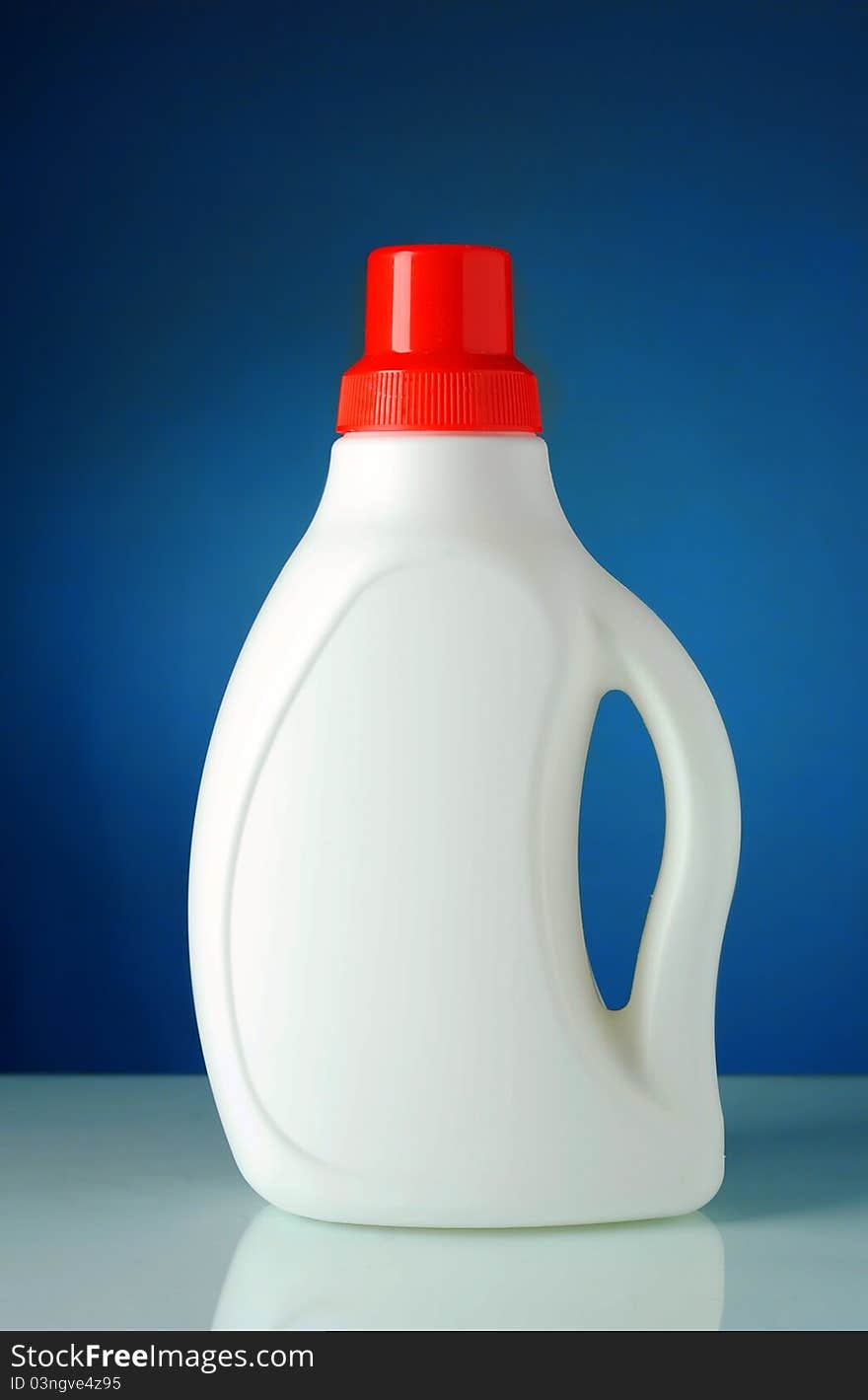 Liquid detergent in a bottle with a blue background. Liquid detergent in a bottle with a blue background