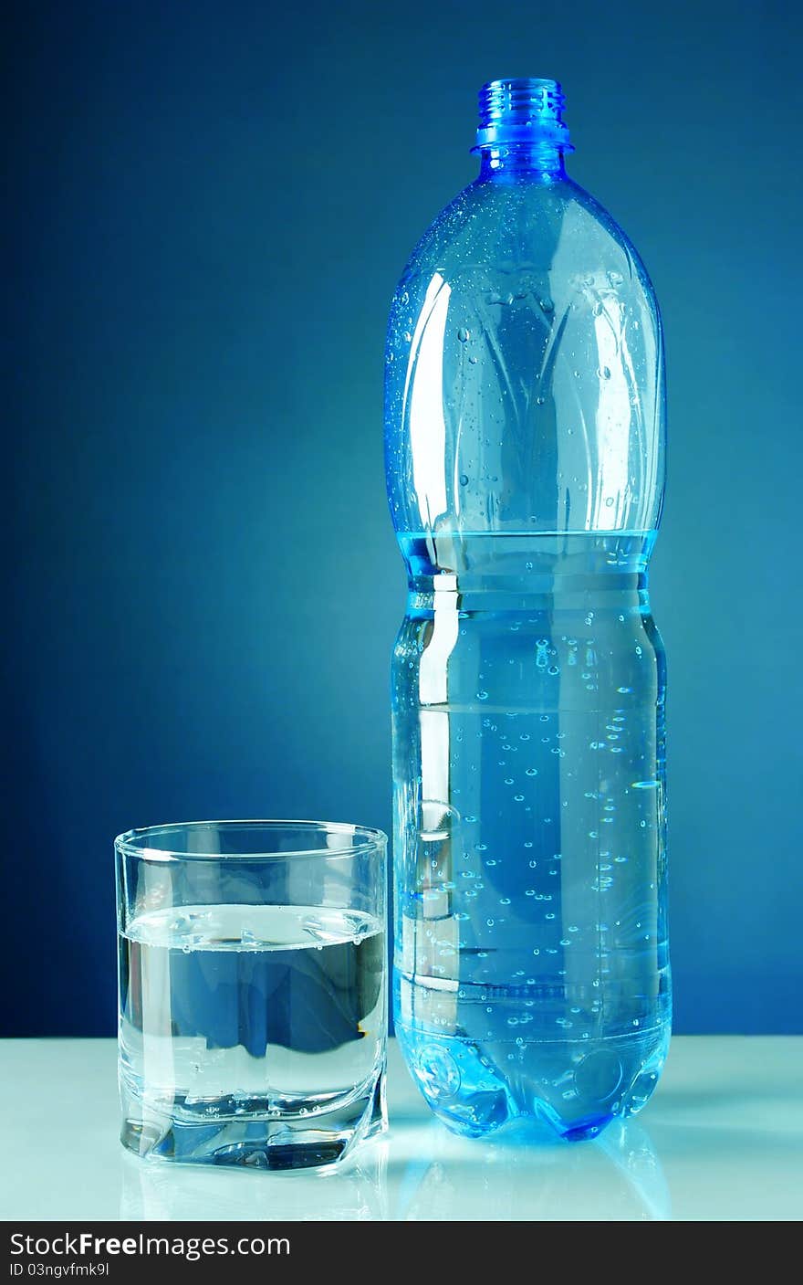 Water in plastic bottle with a blue background. Water in plastic bottle with a blue background