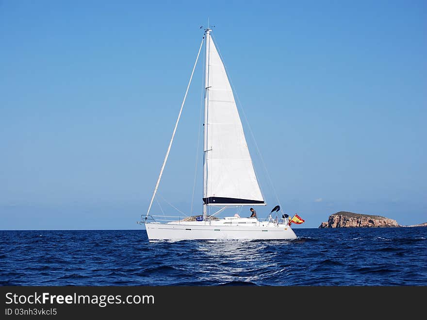 White sailing yacht in the Mediterranean. In the marine reserve of the little islands of Ibiza. White sailing yacht in the Mediterranean. In the marine reserve of the little islands of Ibiza.