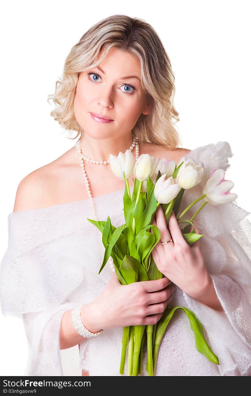 Beautiful young blonde woman with blue eyes holding bouquet of spring tulips wearing cozy woolen shawl on isolated white background. Beautiful young blonde woman with blue eyes holding bouquet of spring tulips wearing cozy woolen shawl on isolated white background