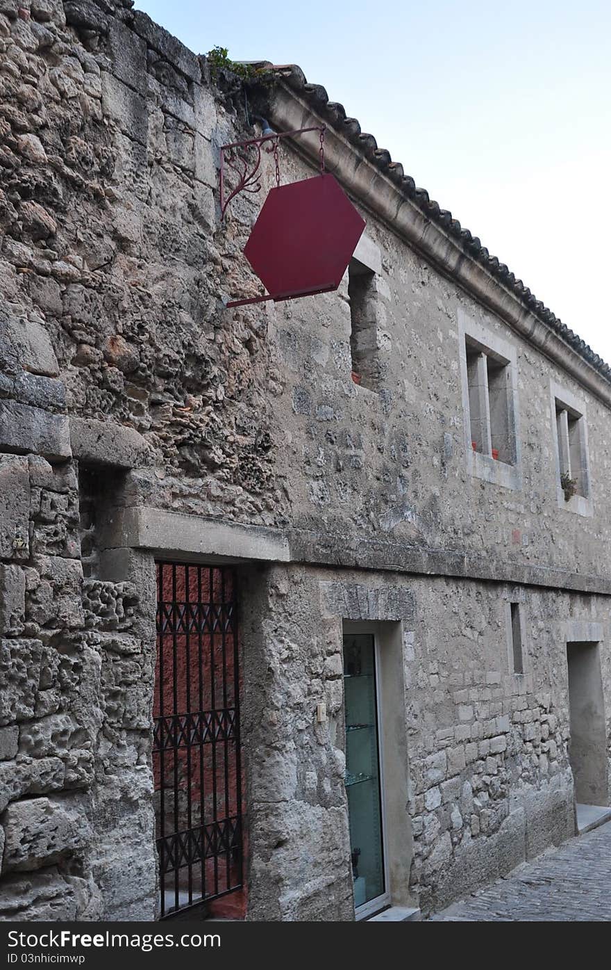 A medieval village with a ruined castle set on a hilltop in the Alpilles mountains. Old castle with iron gate. A medieval village with a ruined castle set on a hilltop in the Alpilles mountains. Old castle with iron gate