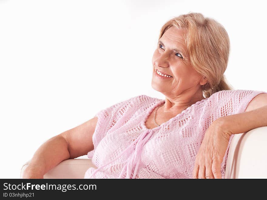 Nice aged woman sitting on sofa on a white